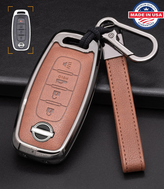 Brown leather Nissan key fob cover with aluminum shell and keychain, featuring engraved details and 4-button design.